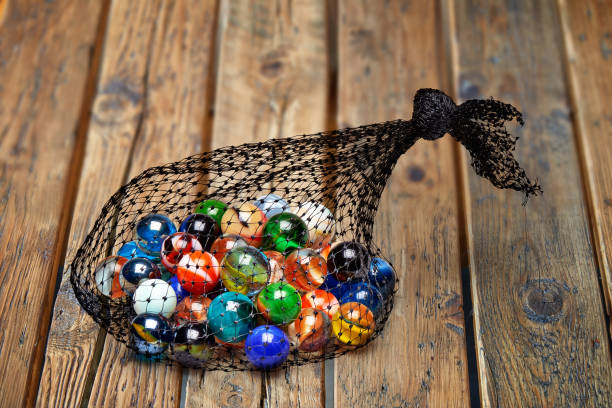Bag of Multicolored marbles on rustic wooden plank table